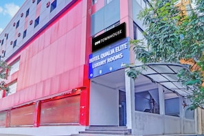 Un edificio de hotel con un letrero que indica 'Hotel Qualia Elite Luxury Rooms' y 'Oyo Townhouse'.