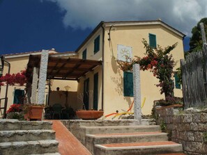 A building with a stone staircase leading to a covered porch area. - Holiday Home With 2 Bedrooms (Marciana)