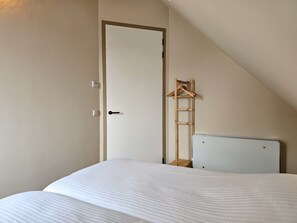 A bedroom with a bed, a white door, a wooden ladder, and a white cabinet. - Holiday Home in Domburg With Swimming Pool (Domburg)