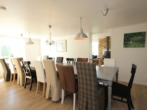 A dining area with a table and chairs, a chandelier, and a fireplace. - Holiday Home in Sandhem With Swimming Pool (Sandhem)