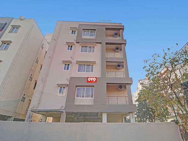 Um edifício de vários andares com varandas e aparelhos de ar condicionado.