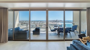 A spacious balcony with a city view, furnished with a sofa, chairs, and a dining table. - Two 1507: Luxury Above the Sea Of Cortez (Puerto Peñasco)