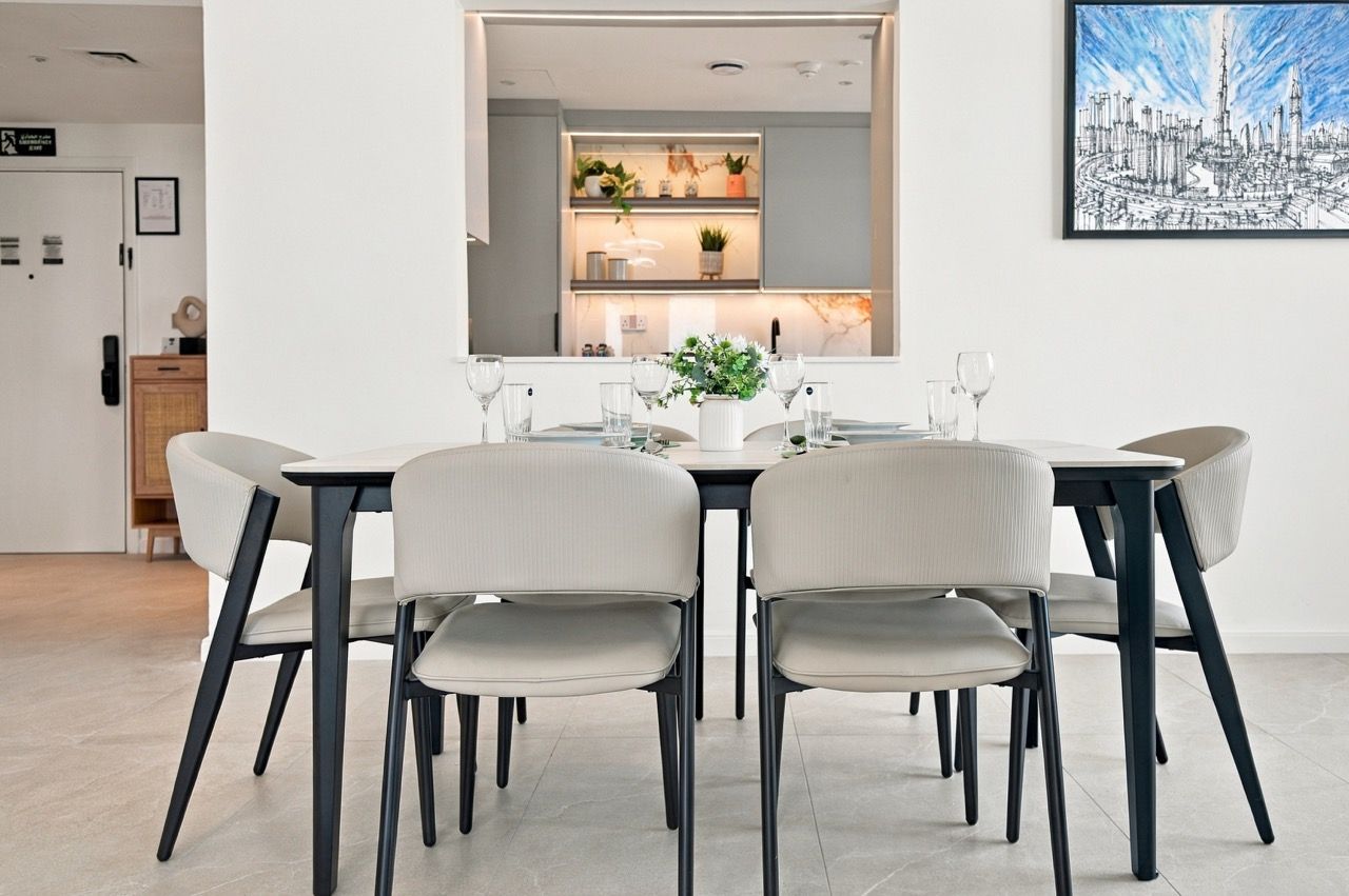 Een moderne eethoek met een rechthoekige tafel, zes stoelen en een bloevas.