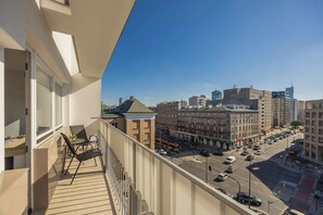 Ein Balkon mit Blick auf eine Stadtstraße, Gebäude und einen klaren Himmel.