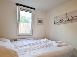 A bedroom with a large bed, a window with blinds, a radiator, and a wall-mounted artwork. - Ok17 Holiday Home Oostkapelle (Oostkapelle)