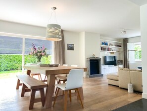 A modern living room with a dining area, a fireplace, and a television. - Ok10, Luxury, Quietly Located Holiday Home (Oostkapelle)