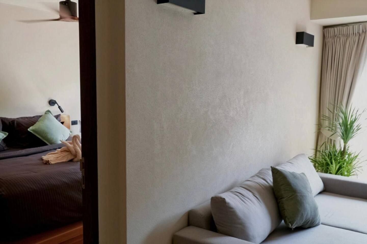 Una sala de estar moderna con un sofá, una mesita y una planta.