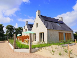 A modern house with a sloped roof, solar panels, and a well-maintained garden. - Holiday Home Zone (Callantsoog)