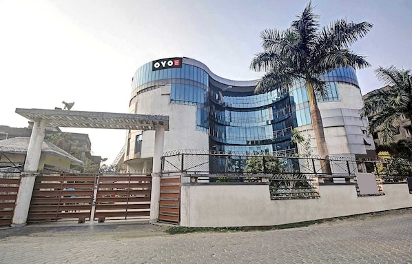 A modern building with a curved facade and a sign that reads 'OYO'. - Collection O Hotel Aqua Villa Near (Kolkata)