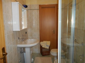 Ein Badezimmer mit Waschbecken, Toilette und Duschbereich.