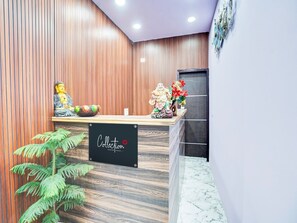 A reception desk with a sign reading 'Collection' and a Buddha statue. - Collection O Hotel Star Inn (Ghaziabad)
