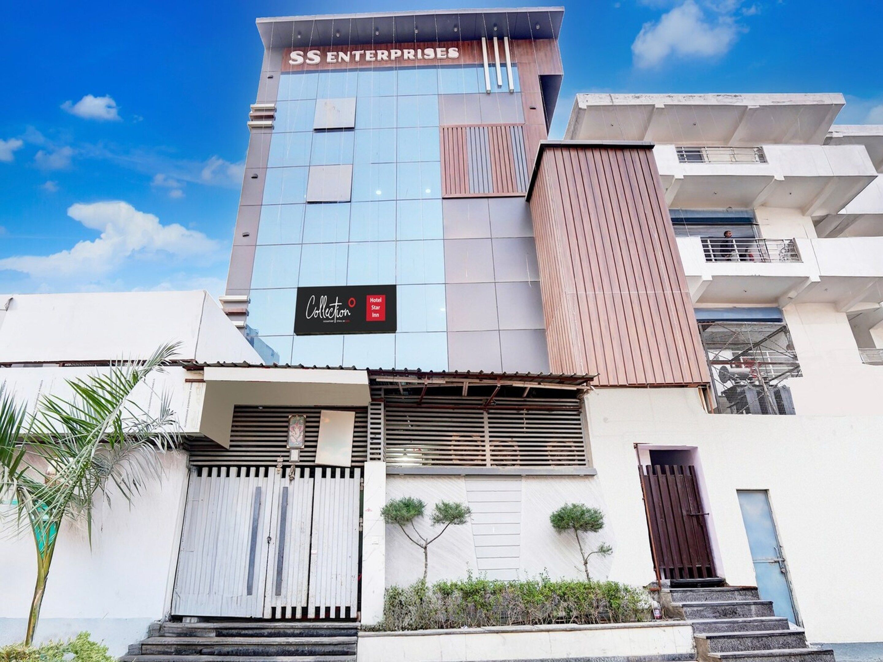 A multi-story building with a prominent sign for 'SS ENTERPRISES' and a 'Collection Hotel Star Inn' sign.