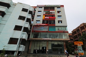 A multi-story building with various commercial establishments including a hotel, an optical store, and a restaurant. - Hotel O Maruti Lodging (Kolkata)
