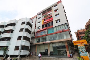 Un edificio de varios pisos con un letrero de BB Eyewear Foundation, un hotel llamado Hotel Maruti Lodging y un letrero de Salón de Banquetes.