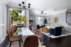 A modern living room with a dining area, a fireplace, and a ceiling fan. - Darling Multi-Level Condo with Stunning Mountain Views & Close Proximity to The Beach! (Santa Barbara)