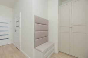 Ein Zimmer mit einem Kleiderschrank, einer Bank und einer Tür.