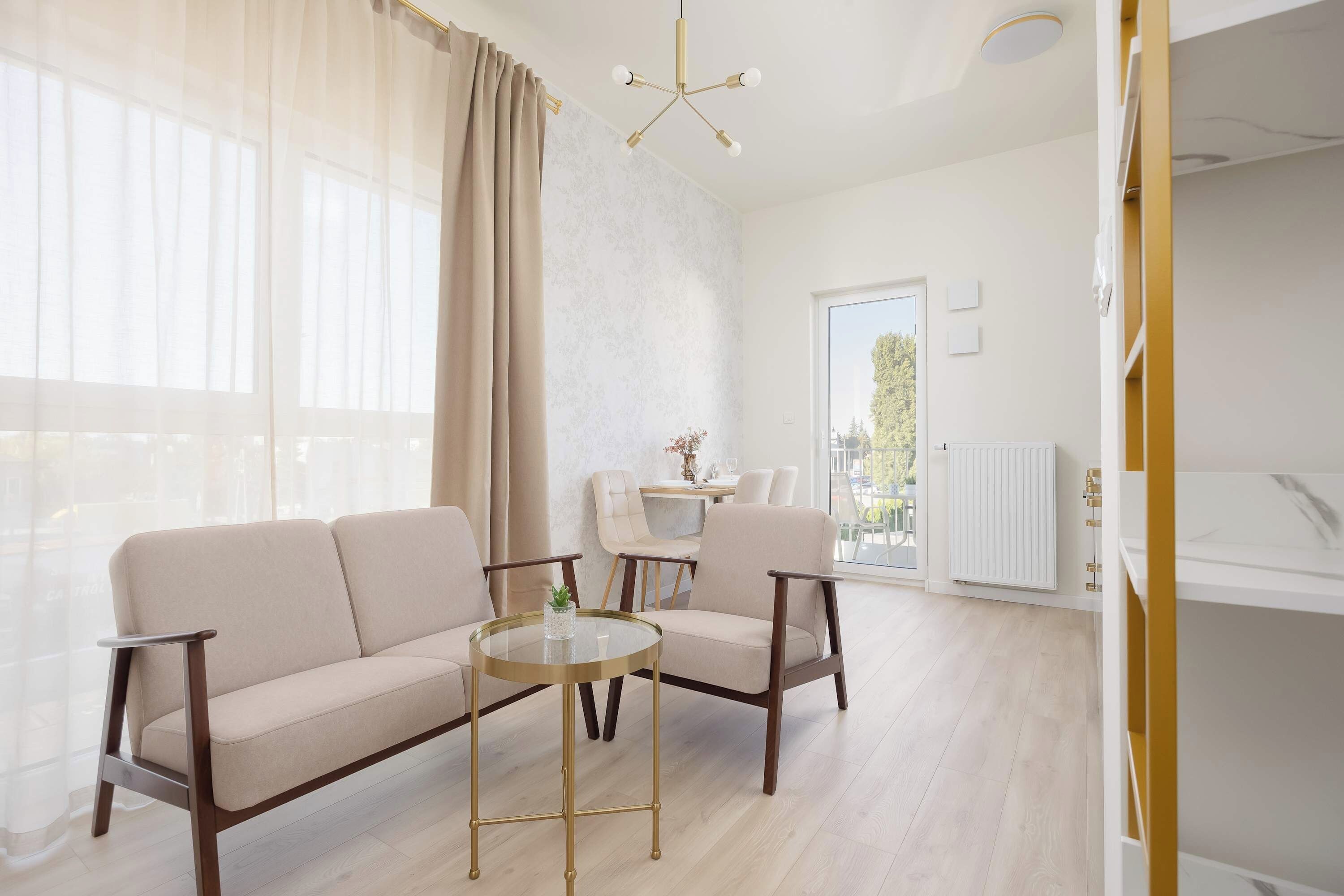 A modern living room with a sofa, chairs, a glass coffee table, and a dining area with a table and chairs.