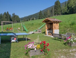 A playground with swings, slides, and a ping pong table. - Edelweiss on the Mahrhof (Monguelfo)