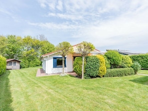 A small, single-story house with a white exterior and a blue window trim. - Holiday Home in Renesse With Swimming Pool (Renesse)
