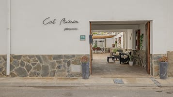 Una entrada a un edificio con un muro de piedra y un cartel que dice 'Col Music'.