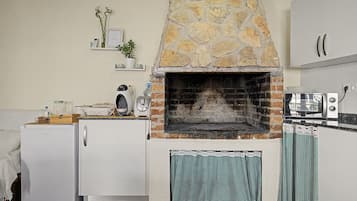 Una cocina con horno de piedra, refrigerador y microondas.