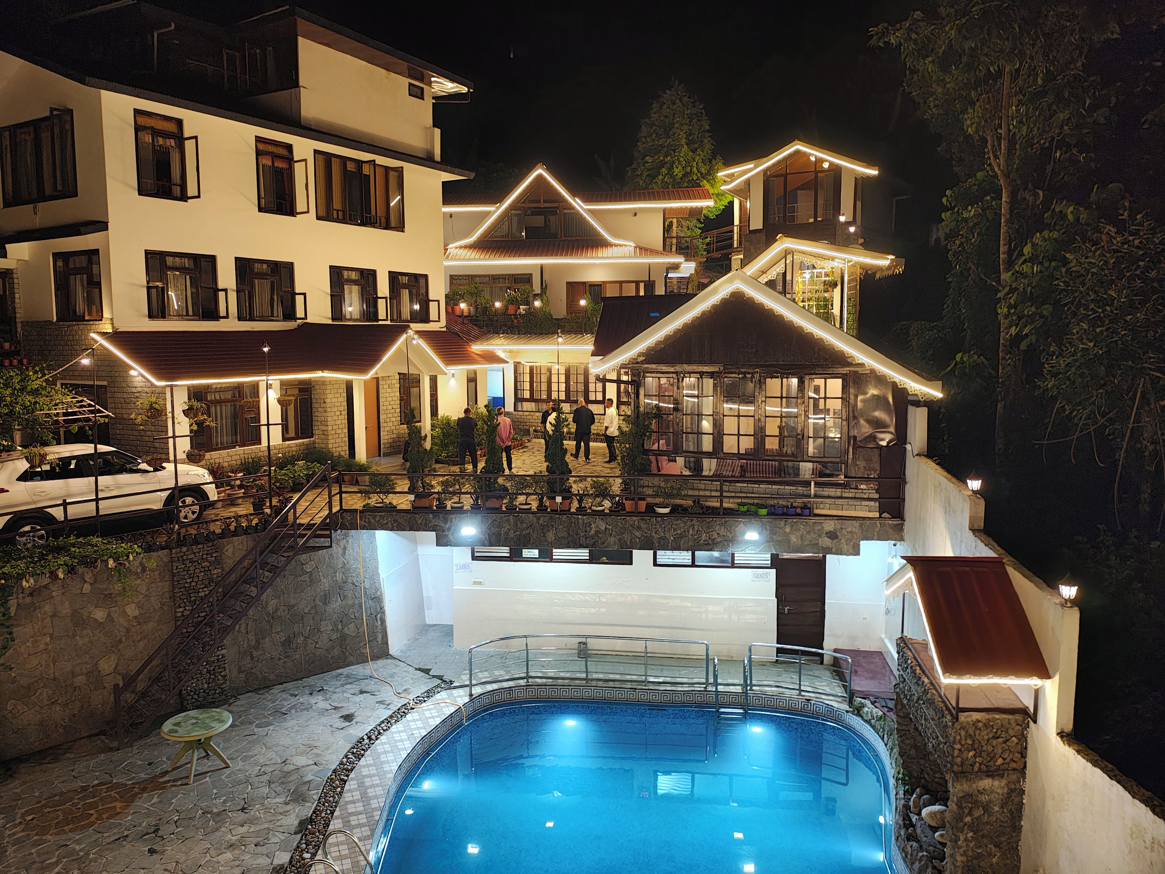 Un edificio de varios pisos con una piscina al final.