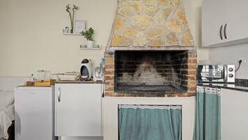 Una cocina con horno de piedra, refrigerador y microondas.
