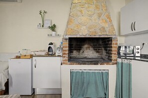 Eine Küche mit einem Steinofen, einem Kühlschrank und einer Mikrowelle.