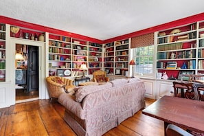 A library with bookshelves, a sofa, and a dining table. - Farm Breakfast + Tap Room • Historic Inn Room | 90 Mins to NYC | The Gables 2 (Dover Plains)