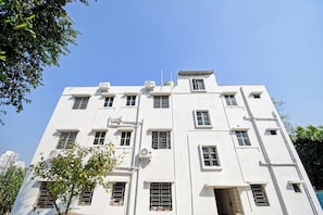 Un edificio de varios pisos con varias ventanas y unidades de aire acondicionado.