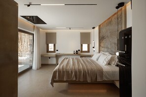 Ein modernes Schlafzimmer mit einem großen Bett, einem Schreibtisch und einem Fernseher.