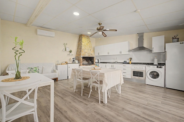 A modern kitchen with white cabinets, a built-in oven, and a washing machine. - Room 'Mirador' with shared terrace, Wi-Fi and air conditioning (Poblenou del Delta)