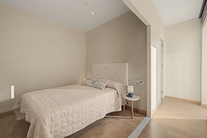 A bedroom with a bed, a bedside table, a lamp, and a door. - Room 'Mirador' with shared terrace, Wi-Fi and air conditioning (Poblenou del Delta)