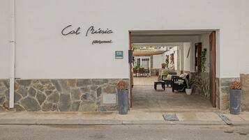 Una entrada a un edificio con un muro de piedra y un cartel que dice 'Col Music'.