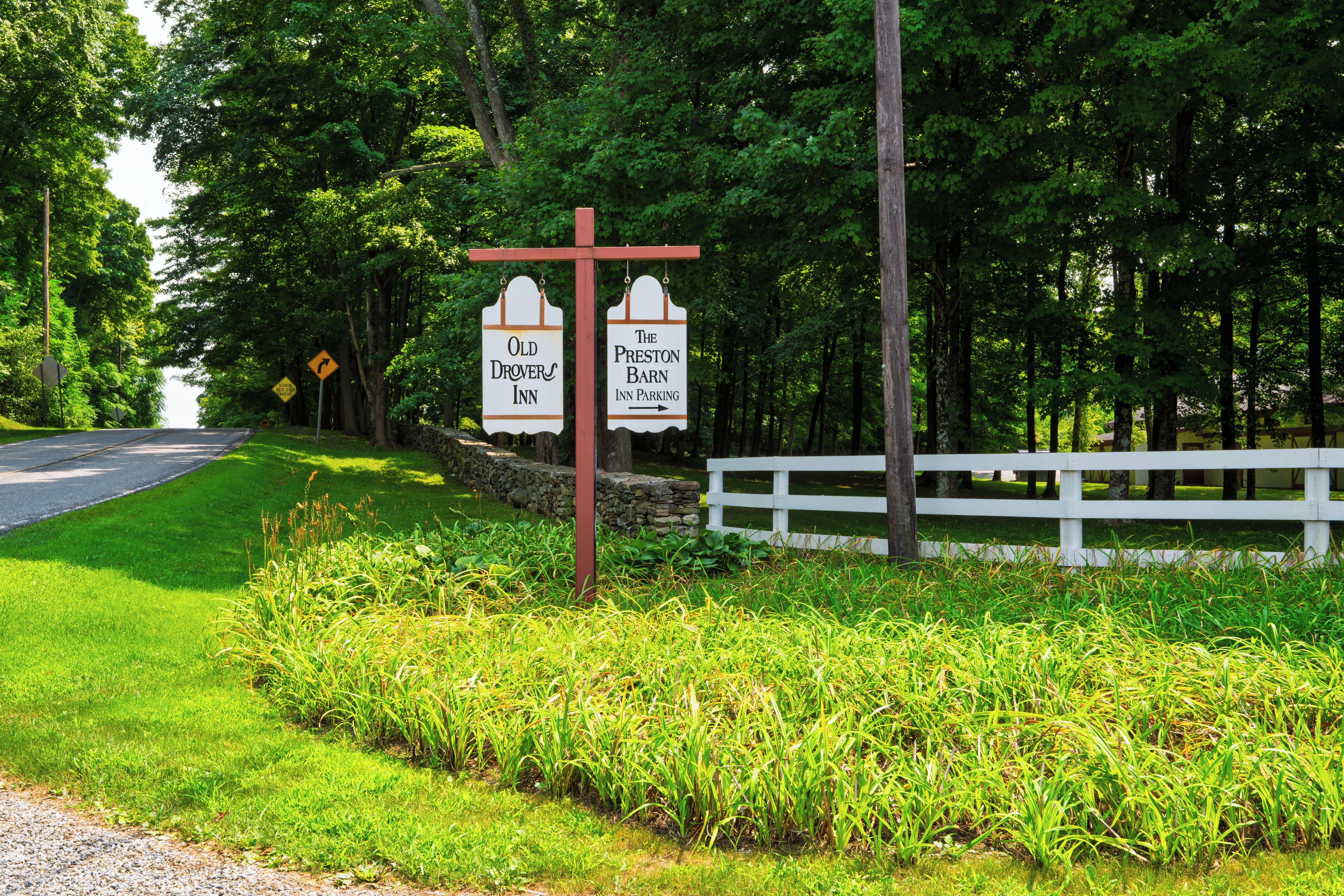 A roadside sign with two directional signs for 'Old Drovers Inn' and 'The Preston Barn Inn Parking'.
