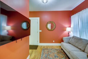 A living room with a sofa, a patterned rug, a television, and two wall-mounted mirrors. - Brevard Retreat w/ Hot Tub & Copper Soaking Tub (Brevard)