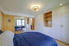 Une chambre à coucher avec un grand lit, une armoire et un miroir.