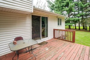 Une terrasse couverte avec une table et des chaises, une porte-fenêtre coulissante et une terrasse en bois.