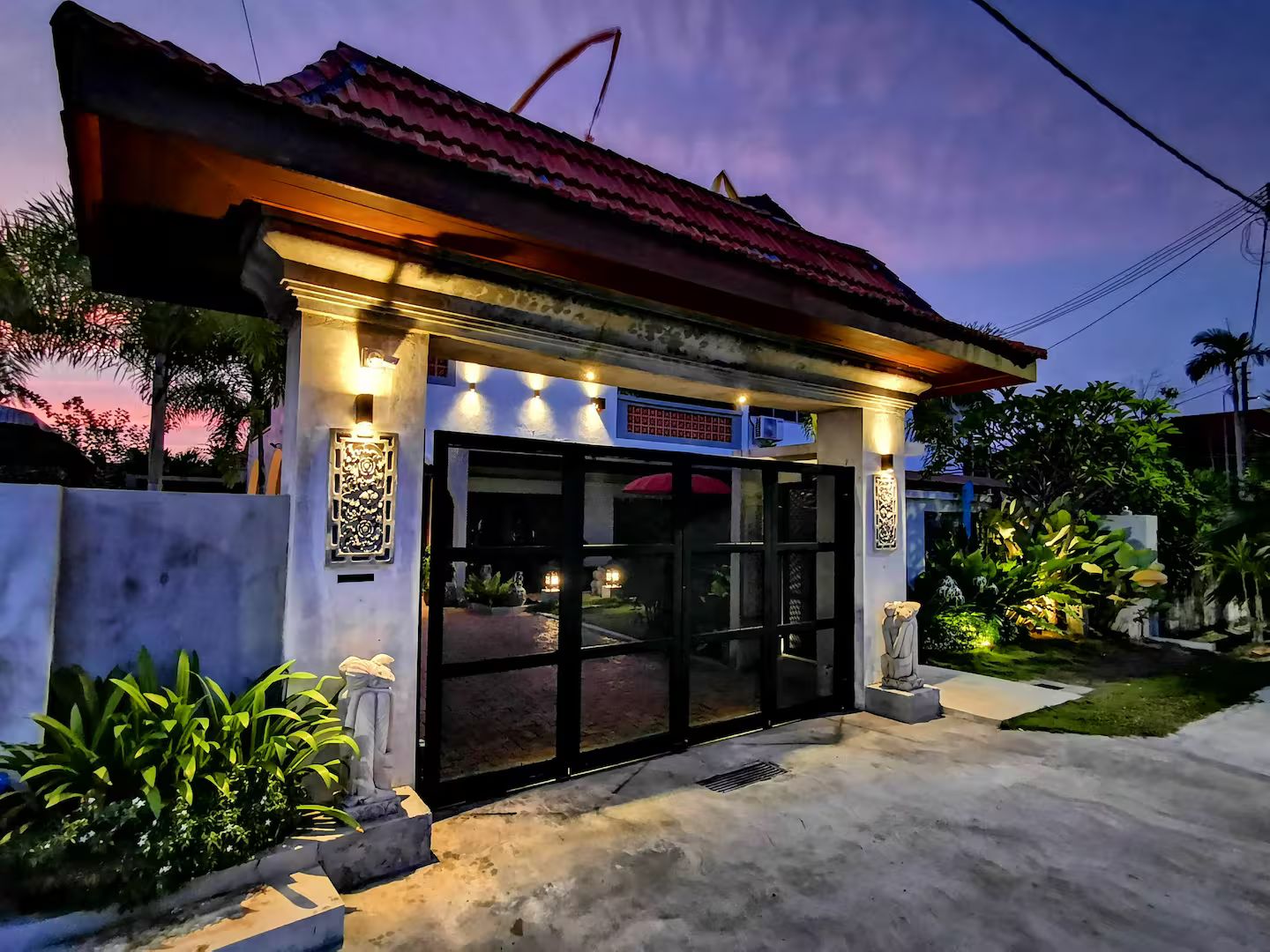 A building with a tiled roof, a glass entrance, and outdoor lighting.