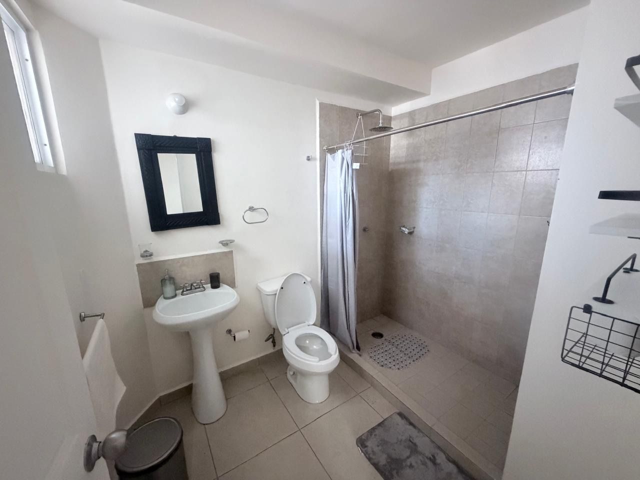 A bathroom with a toilet, sink, and shower.