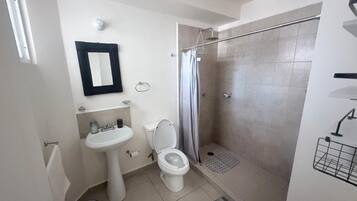 A bathroom with a toilet, sink, and shower.