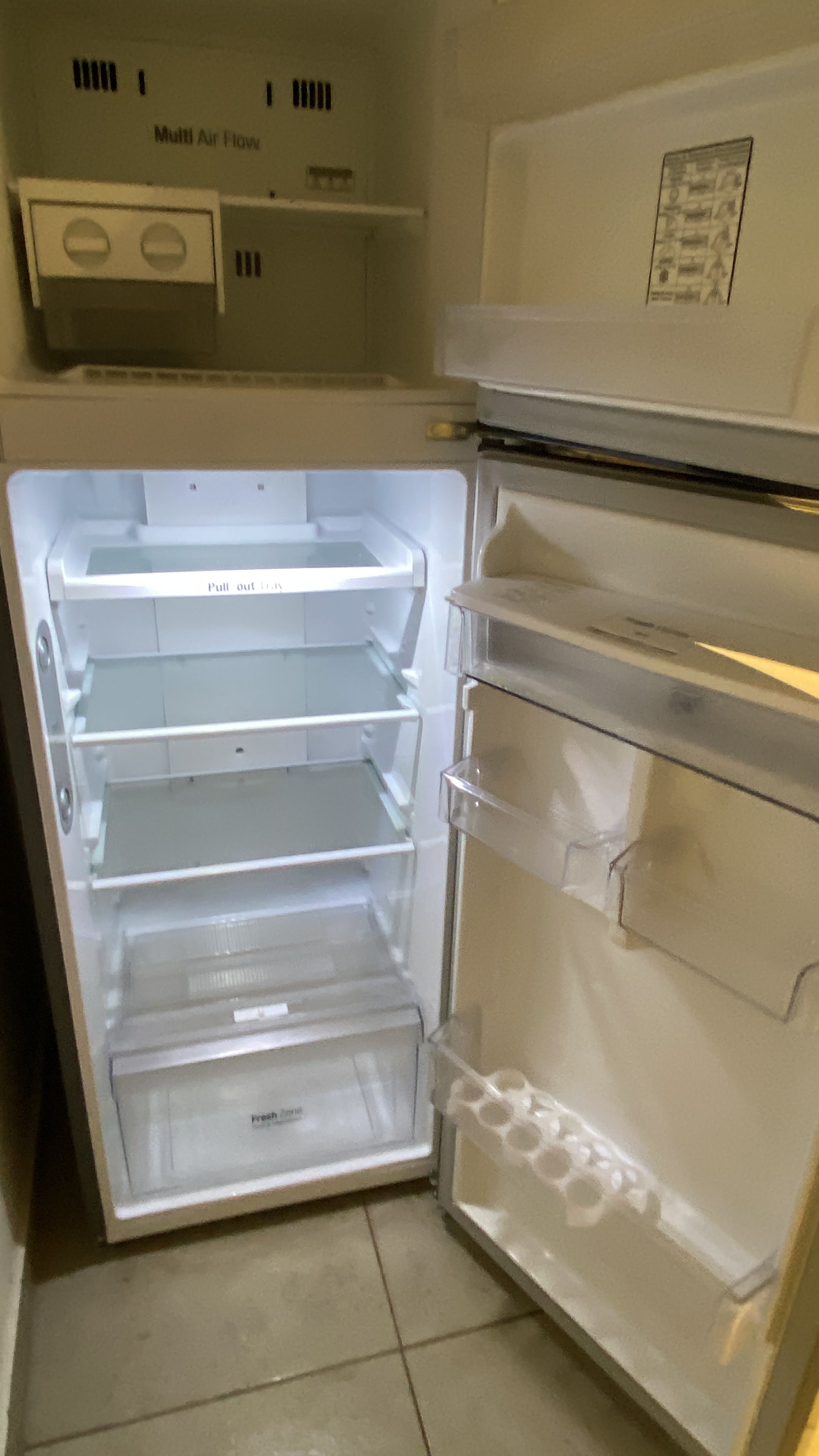 An open refrigerator with multiple shelves and drawers, including a fresh produce drawer.