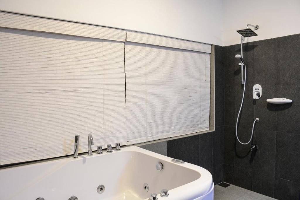 A modern bathroom with a freestanding bathtub, a showerhead, and a toilet.