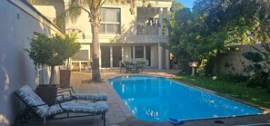 Ein Wohngrundstück mit Swimmingpool, Territäten und einem überdachten Sitzbereich.