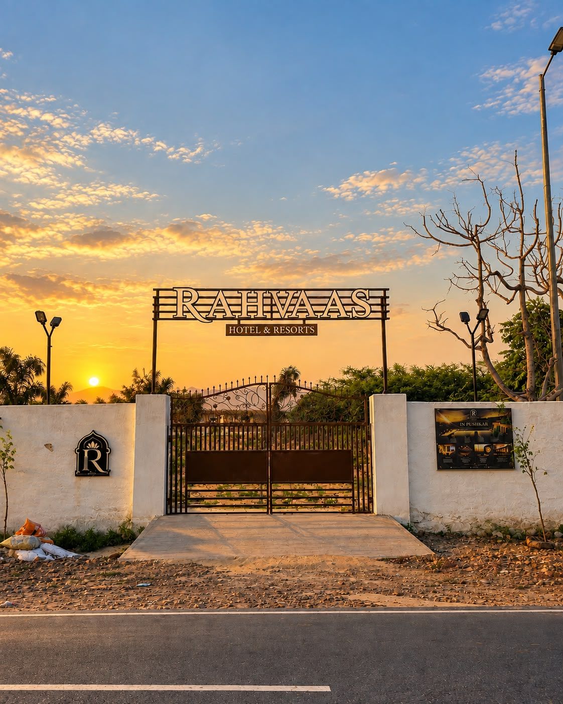 Une entrée fermée par un portail, sur laquelle on peut lire l’inscription « RAHVAAS HOTEL & RESORTS », et un logo est affiché sur le mur.