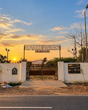 A gated entrance with a sign reading 'RAHVAAS HOTEL & RESORTS' and a logo on the wall. - Rahvaas Hotel & Resorts (Pushkar)