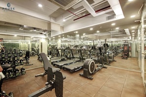 Ein Fitnessstudio mit Laufbändern, Kraftgeräten und Kurzhanteln.