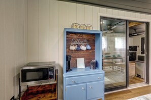 Eine Küche mit einem blauen Schrank, einer Mikrowelle und einer Kaffeemaschine.