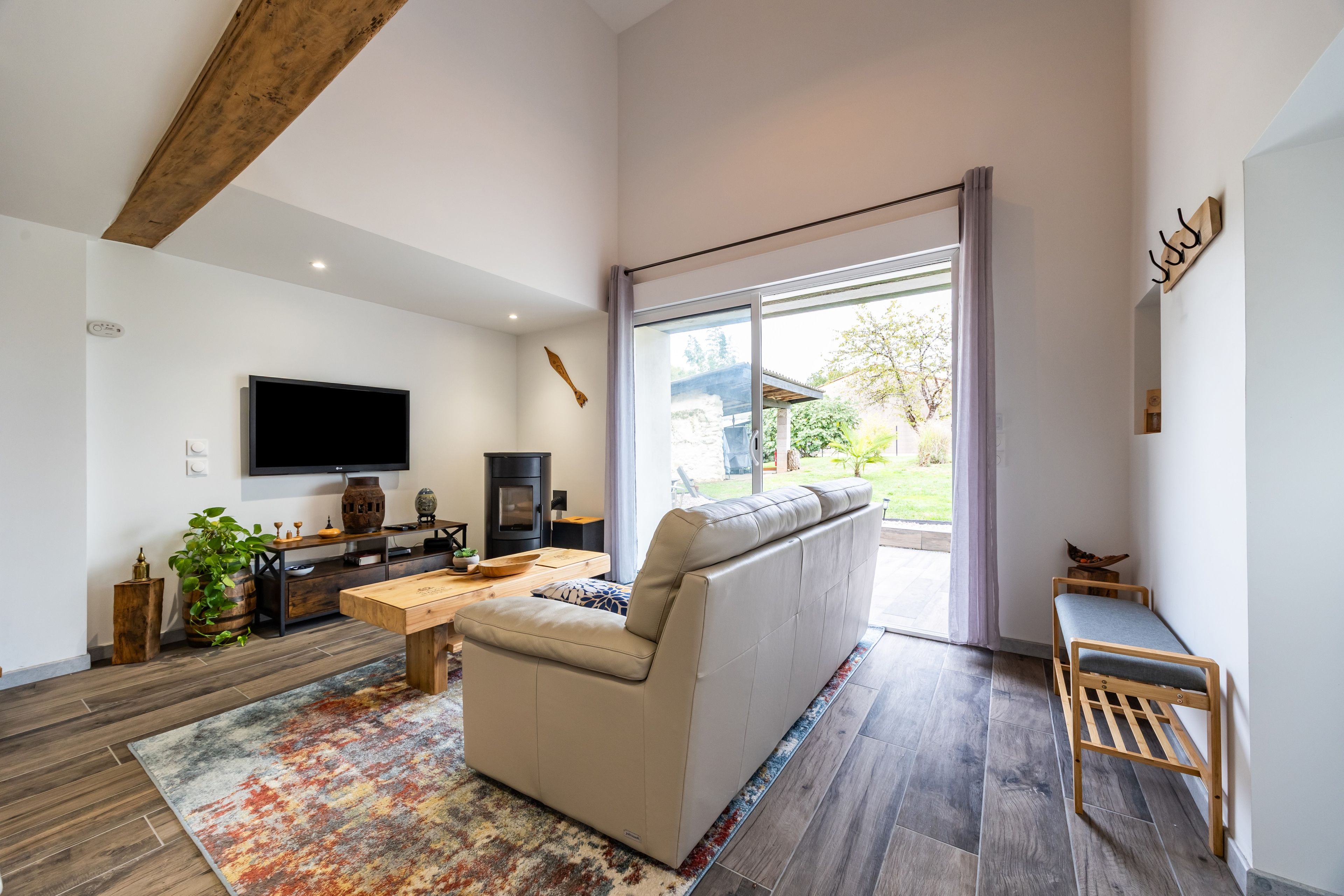 Een moderne woonkamer met een grote bank, een flatscreen televisie en een houten salontafel.