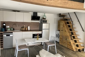 Eine moderne Küche mit integriertem Mikrowellenherd, einer Spüle und einer Holztreppe.